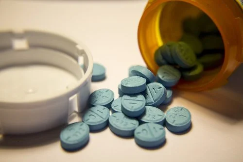 Blue prescription pills spilled from bottle