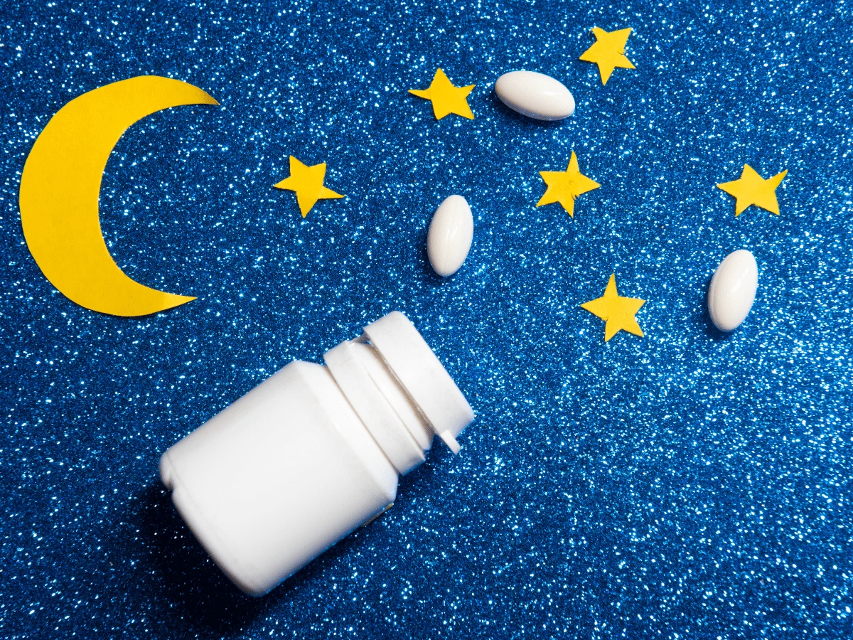 Bottle of pills next to a cut-out moon and stars