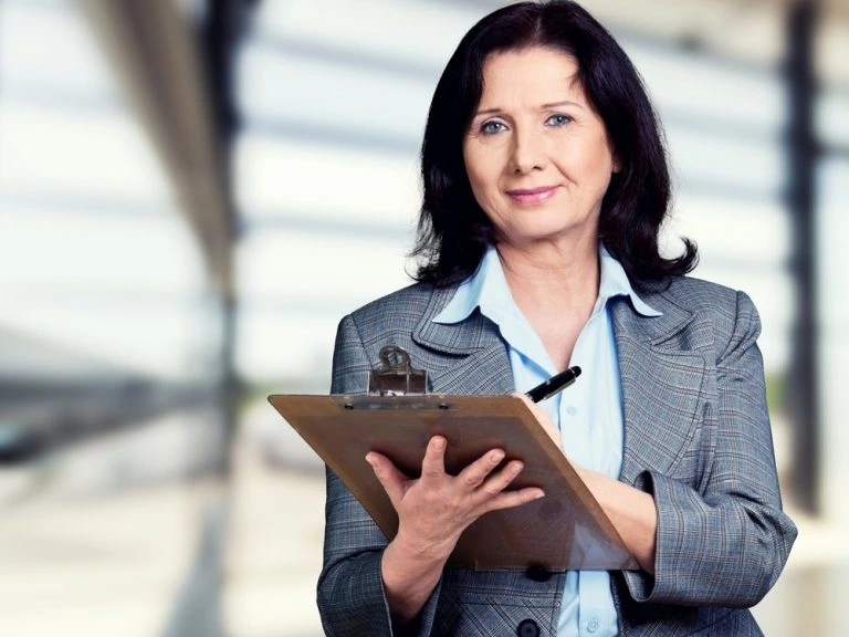 Confident businesswoman holding clipboard