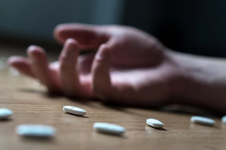 Drug overdose hand scattered pills