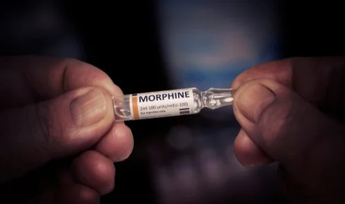 Hands holding morphine ampoule