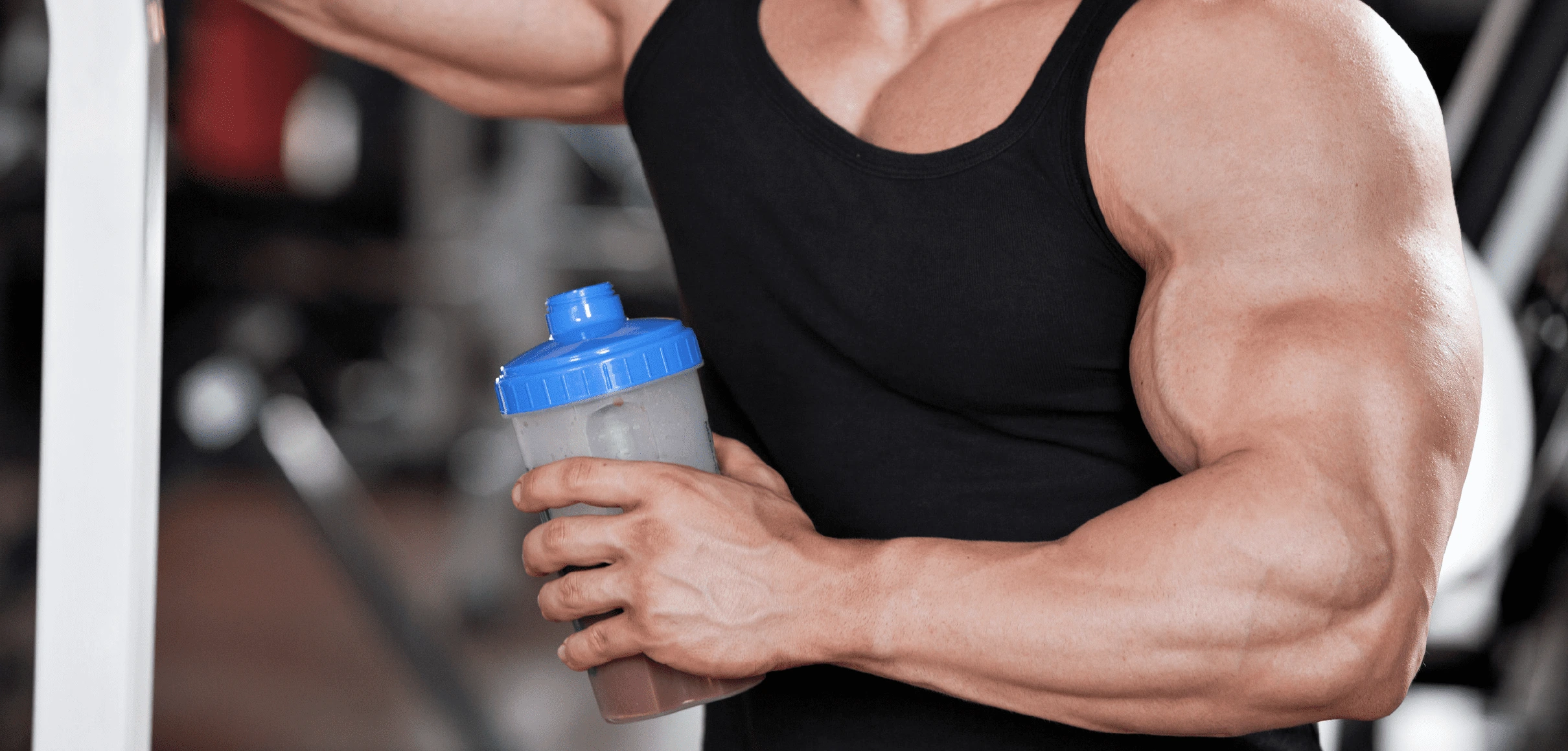 Muscular man holding protein shaker