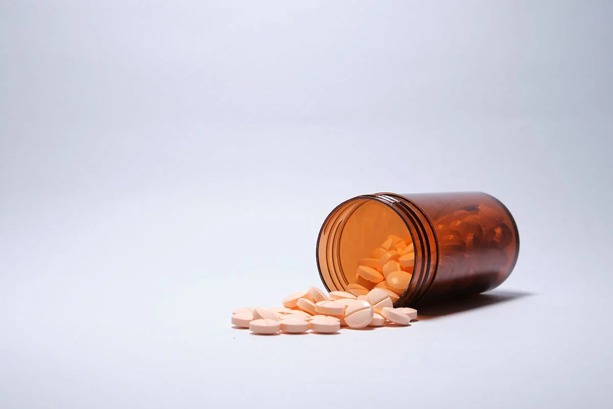 Orange pill bottle with pills spilled