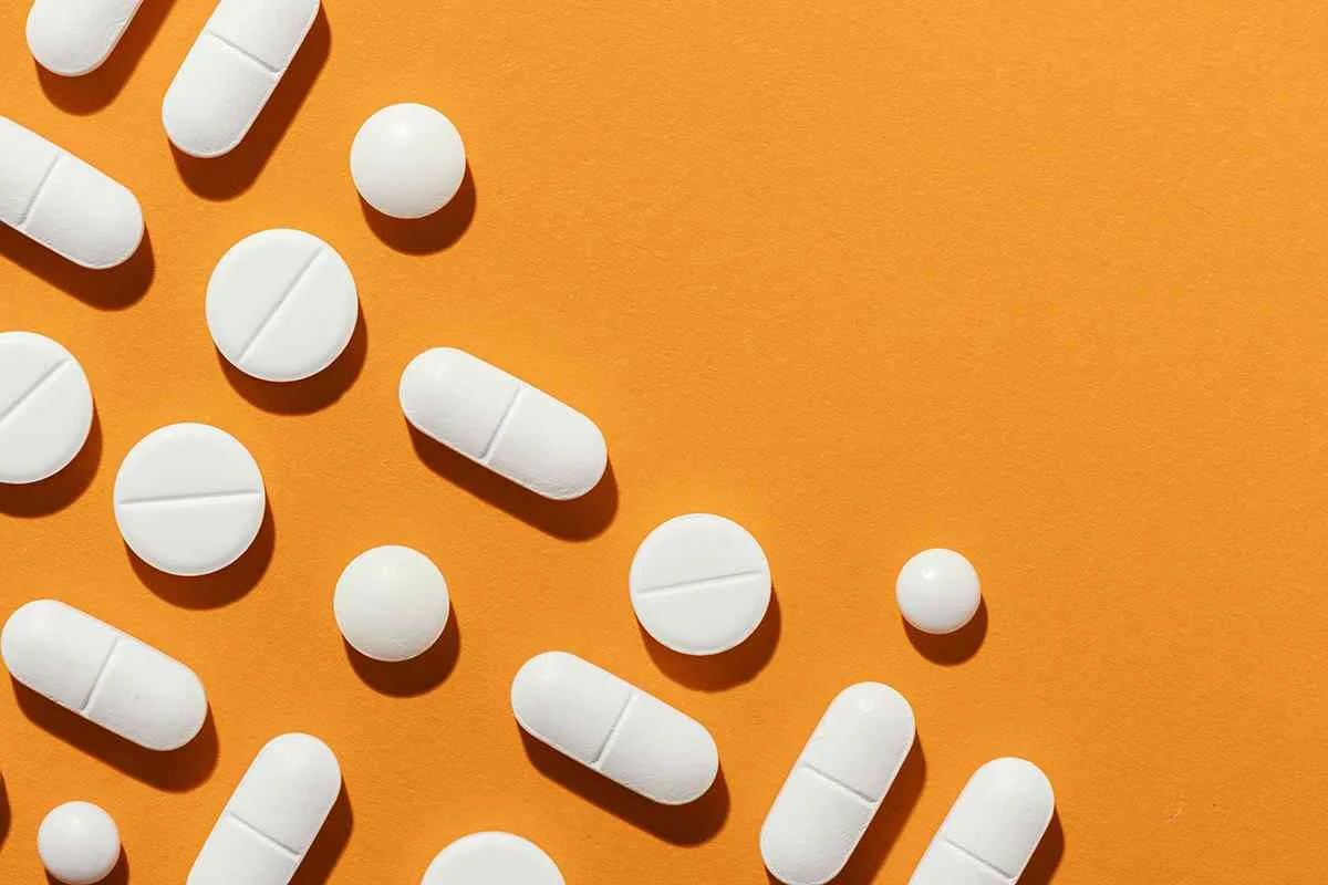 White pills on orange background