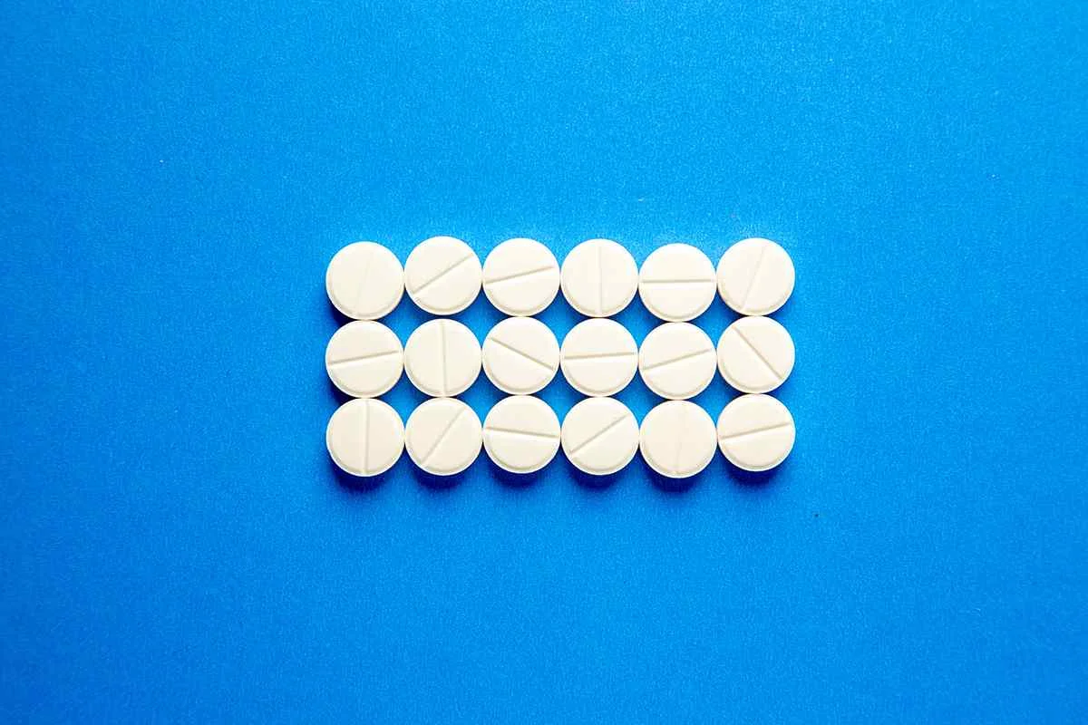 White round pills on blue background